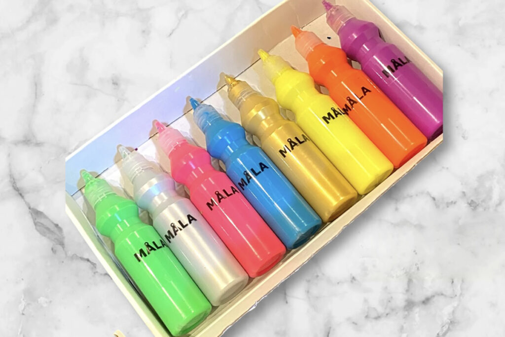 IKEAのMÅLA絵の具セット。8色のカラフルなボトルが箱に並んでおり、蛍光色やメタリックカラーが目を引く。