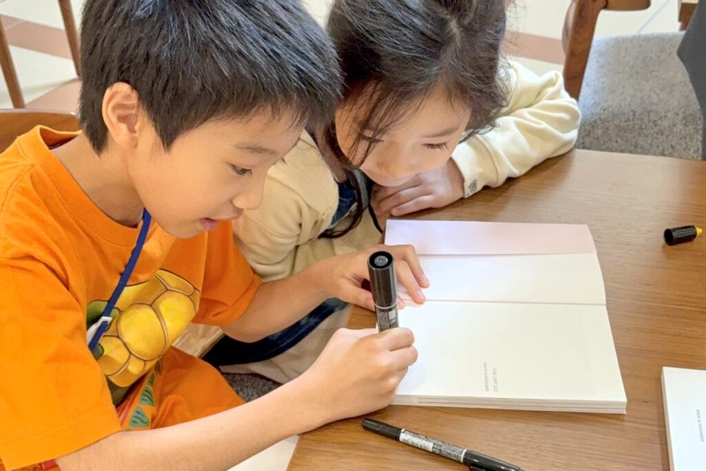 大塚国際美術館で画集にサインするAKASHI