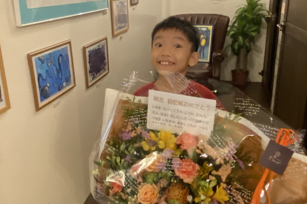 花束を抱えて満面の笑顔を見せるAKASHI