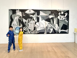 ゲルニカの前に立つAKASHIとRIRI。新しい絵旅のはじまり