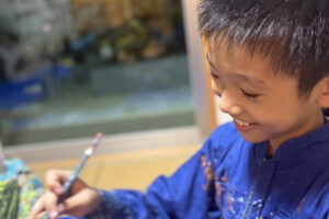 絵を描きながら笑顔を見せるAKASHI