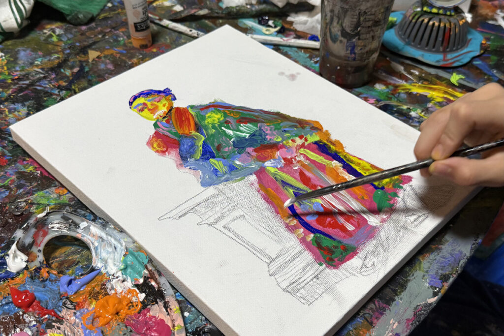 坂本龍馬の絵を描き始めるAKASHI。カラフルな絵の具を使い、下描きに命を吹き込んでいる様子。