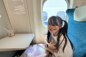 新幹線の座席で笑顔を見せるRIRI